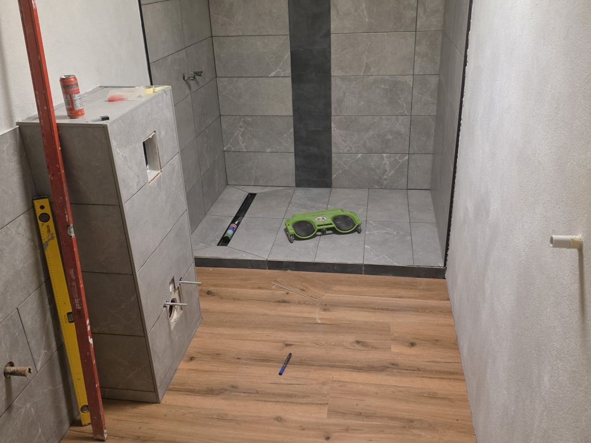 Badsanierung durch HS Haustechnik in Werdohl: neue Bodenfliesen in der Dusche und Vinylboden in Holzoptik